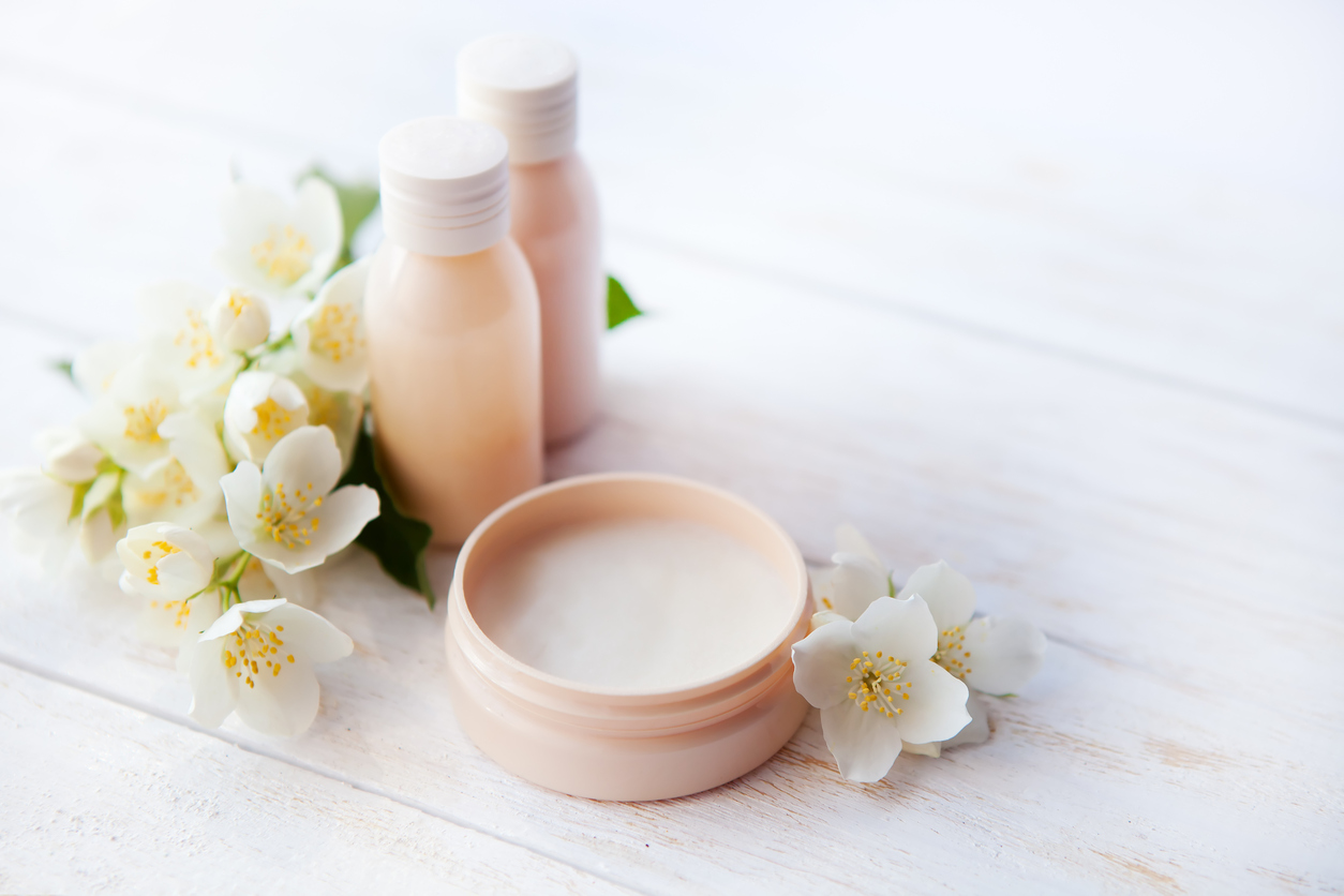 Spa setting with beauty cream and white  flower